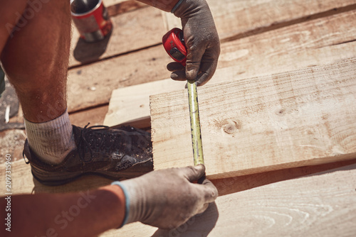 Fotografie Construction worker working outdoors on a roof renovating.