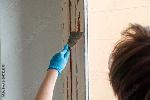 Canvastavla Woman Removing Old Paint from Wooden Window Frame with Putty Knife