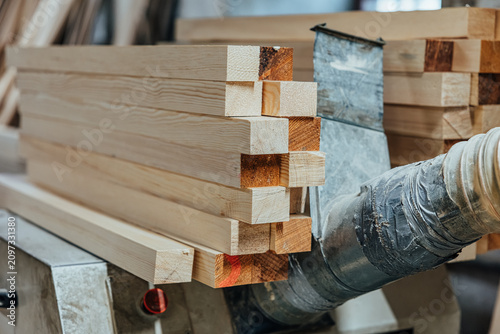 Foto Close-up of neatly stacked planed softwood timber beams with visible wood grain and clean cut ends in a woodworking or construction workshop