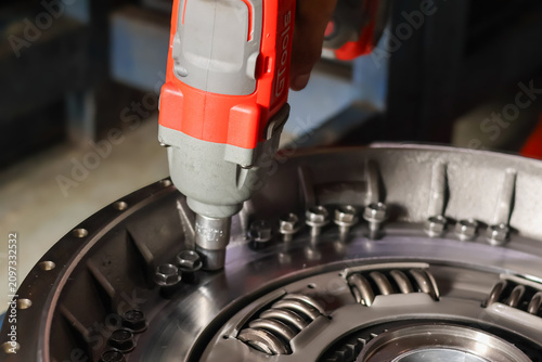 Tableau sur toile Mechanic using cordless impact wrench to tighten clutch assembly bolts