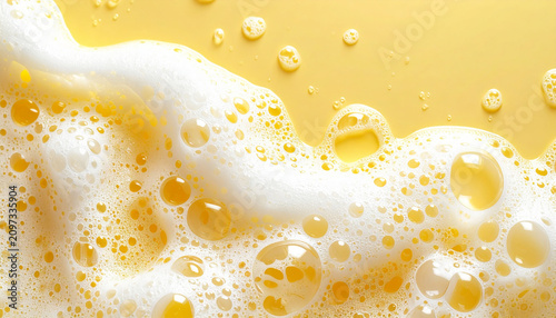 Soft soap foam texture with delicate shampoo bubbles on pastel yellow background, hygiene and bath care concept, clean beauty aesthetic, minimal composition. Close-up.