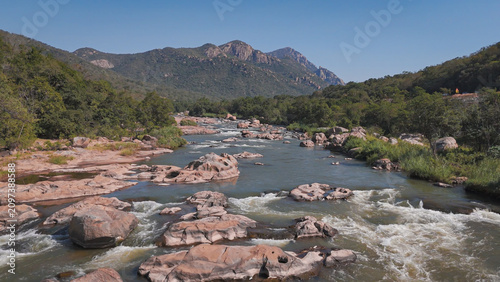 Drone photograph of Crocodile River in Mpumalanga, South Africa, early morning July 202
6, showing flowing water and stones in natural landscape.