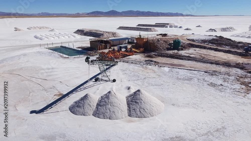 Drone aerial video of salt processing facility, conveyor and white piles in Salinas Grandes, Argentina.