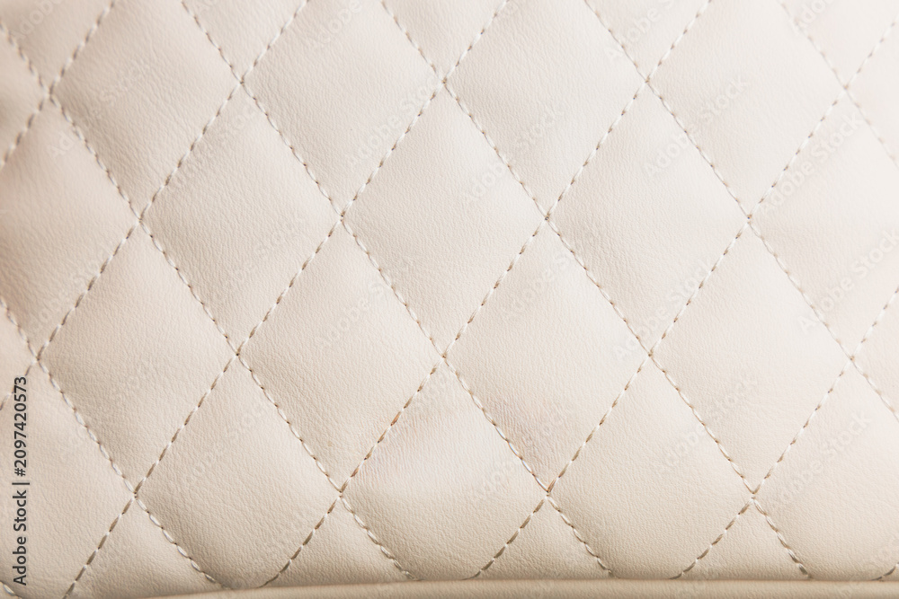 Obraz premium Close up view of leather textured white background showing diamond pattern with stitching and soft material
