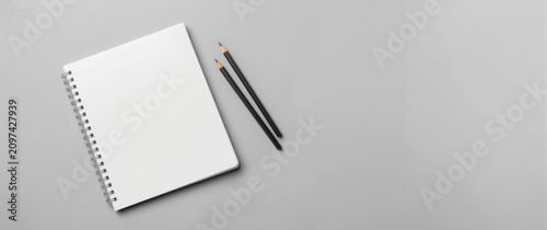 Blank Sketchbook and Two Pencils on Grey Table Surface