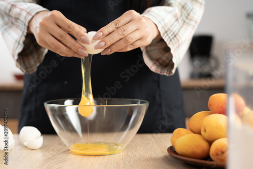 Принти на полотні Close-up of Making liquid dough. Woman adding eggs into bowl
