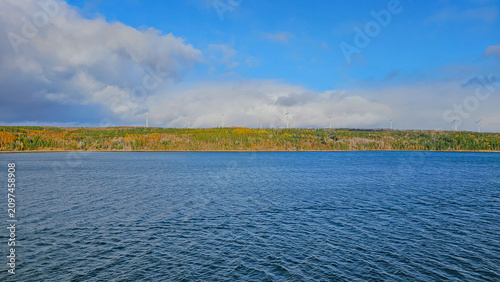 Photography Scenic landscape shot of several modern wind turbines on a colorful autumn fores