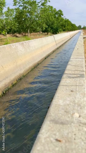 Agua corriendo por acequia de regadío 