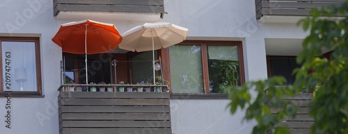zwei Sonnenschirme auf einem Balkon