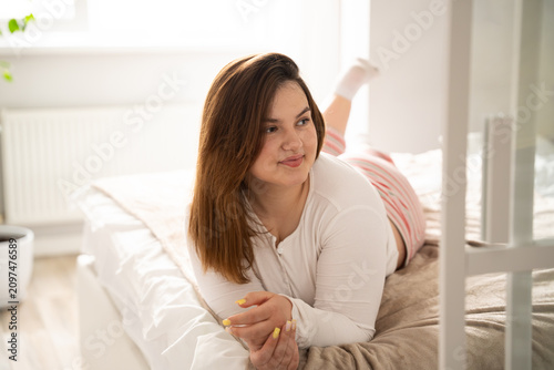 Young woman enjoying a serene morning in bed at home. Self care and mental wellness through home relaxation and morning routine