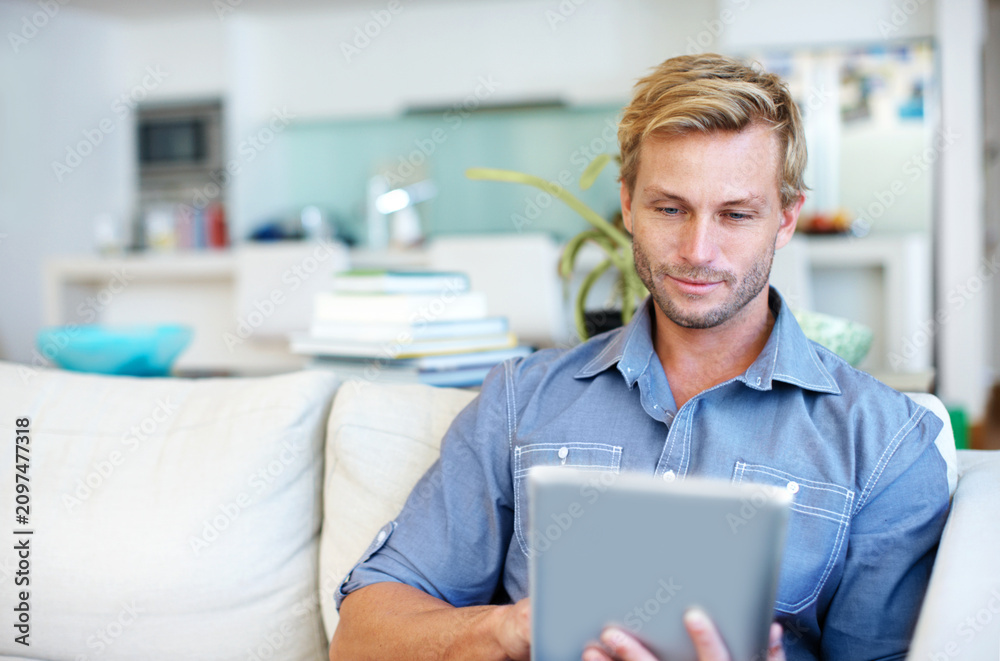 Fototapeta premium Man, internet and remote work in home with tablet, research trend and AI software for logo design. Freelancer, person or graphic designer on sofa with tech, planning or innovation for digital project