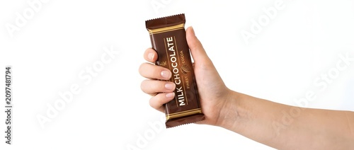 Hand holding milk chocolate bar snack food treat