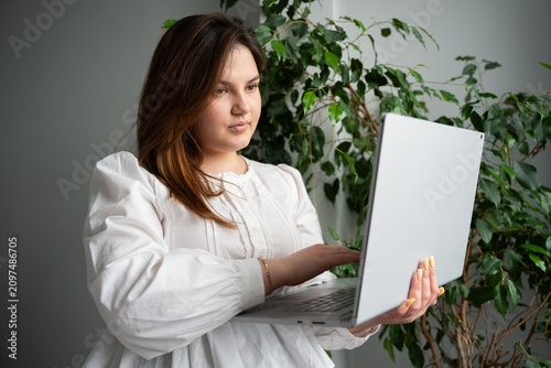 Focused woman using a laptop in a cozy home office environment. Remote work digital productivity and flexible workspace