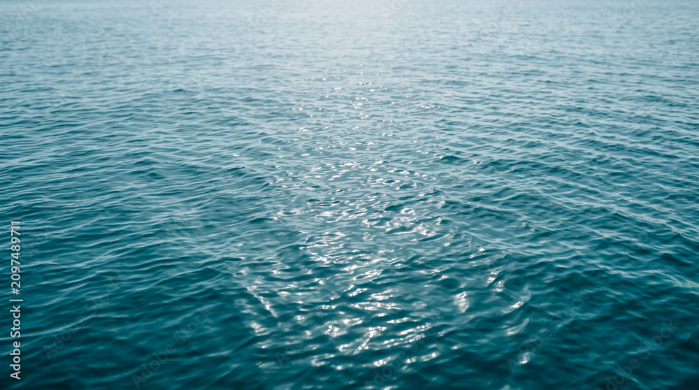 Obraz premium Blue ocean water surface. Rippling sea waves reflecting bright sunlight.