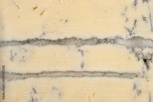 Foto A detailed horizontal macro shot showing the creamy texture and distinct grey mold veins inside a gourmet blue cheese slice