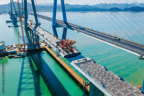 Aerial view of a modern cable-stayed bridge under construction showing heavy machinery and engineering progress, Ningbo, China
