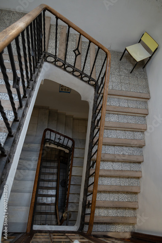 фотографія High angle view looking down an old school stairwell with wooden handrail and a