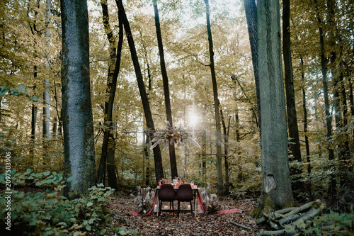 Foto Styled wedding table with a floral chandelier in an autumn forest