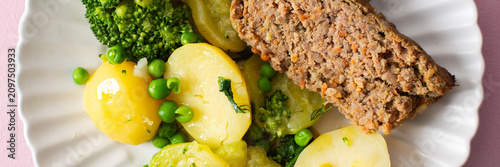Obraz na plátně A plate of boiled potatoes, turkey meat pie, broccoli, and green peas is ready for breakfast