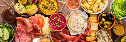 Foto Enjoy a vibrant charcuterie board filled with assorted cheeses, savory sausages, creamy hummus, nuts, and colorful vegetables