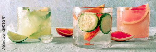 Refreshing summer cocktails with ice cubes on a light background