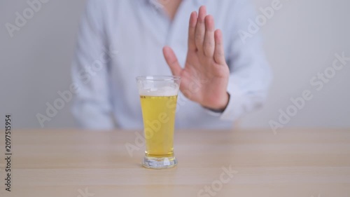 man making stop hand gesture to refuse a glass of Beer, Healthy man say no to alcohol drink, stop alcoholism and addiction concept. Responsible man reject a drink before driving and quit booze