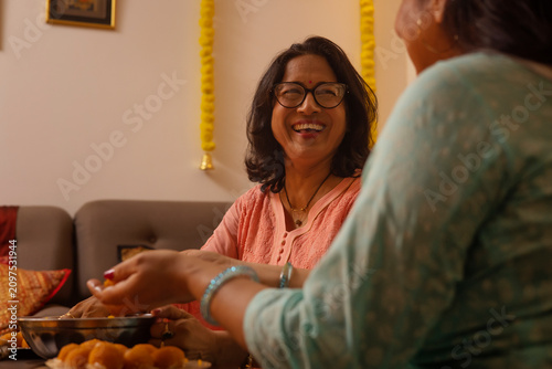 Mother-in-law and daughter-in-law making laddoo on the occasion of Diwali