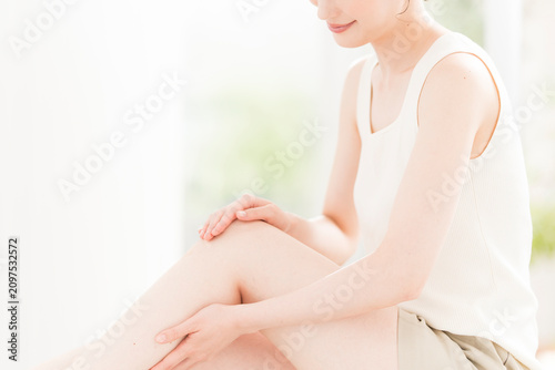 ボディケア。脚のスキンケアやマッサージをする若い日本人女性