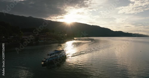 Aerial drone of small ship on Lake Toba in the rays of the sun. Sunset in the tropics.Sumatra. Indonesia.