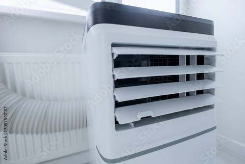 Extreme macro close-up of open adjustable louvers on modern mobile monoblock air conditioner unit