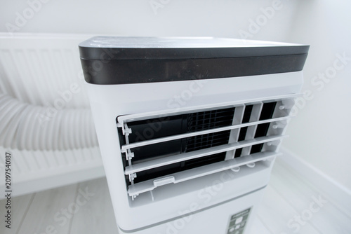 Extreme macro close-up of open adjustable louvers on modern mobile monoblock air conditioner unit