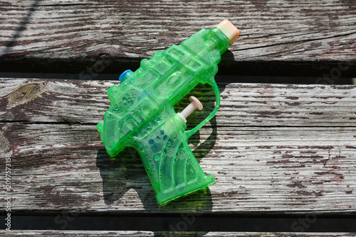 Green water pistol on weathered wood