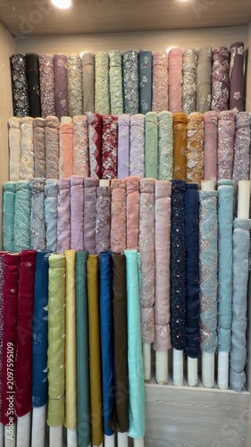 Vibrant embroidered suits, fabrics, and bridal lehengas elegantly arranged inside a Pakistani clothing boutique.