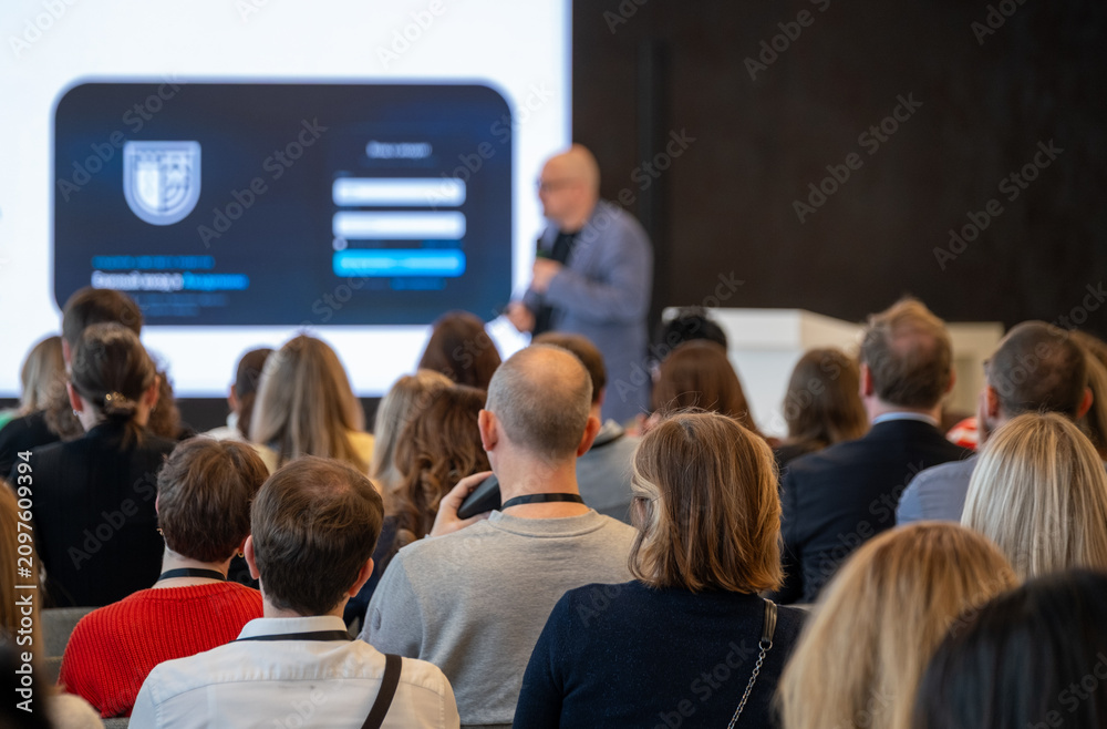 Fototapeta premium Business audience seated and focused on presenter, corporate seminar with networking and learning atmosphere.