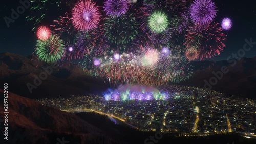 Spectacular Colorful Fireworks Display Lighting Up the Night Sky Over a City Nestled in Mountains