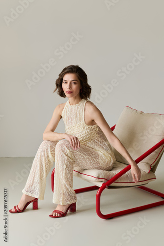 Elegant brunette woman showcasing chic white lace outfit in stylish setting