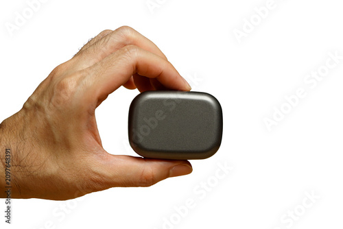 man's hand isolated over white wall background holding bluetooth wireless earphones.white background