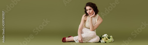 Foto Brunette woman with bob haircut poses in a stunning lace ensemble near flowers,