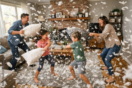 Family having a fun pillow fight at home with feathers flying everywhere