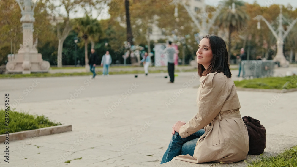 Obraz premium Woman Sitting On Park Bench In Trench Coat