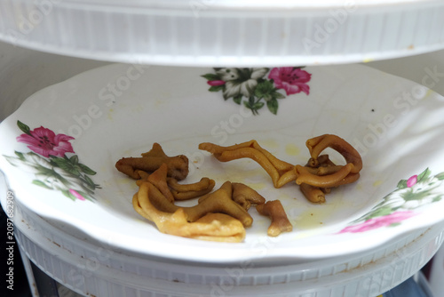 Obraz na płótnie yellowish cooked animal intestines or tripe served on a white ceramic plate