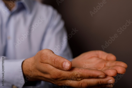 Photos Man's open hands extended forward, implying giving or receiving, with care