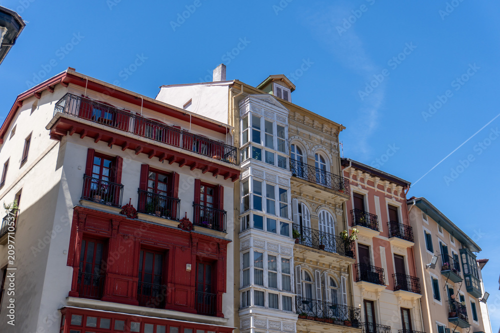 Obraz premium Colorful historic buildings with balconies under a clear blue sky
