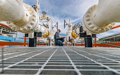 Male worker inspection at steel long pipes and pipe elbow in station oil factory during refinery valve of visual check record pipeline