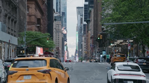 Iconic yellow cab driving through busy Manhattan traffic toward Times Square with skyscrapers and bustling pedestrians on Seventh Avenue in New York City, United States. 02,02,2026, New York, USA, 