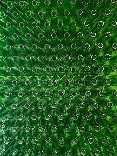 Abstract background of green glass bottles. Concept of glass recycling, reusable bottles, circular economy, bottle deposit return system (Pfand) and sustainable waste management.
