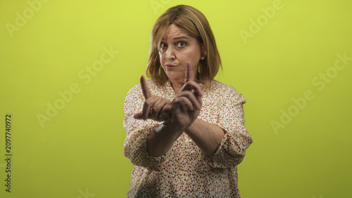 Bild auf Leinwand Woman pointing index finger toward camera in studio, patterned blouse visible and hand extended with stern expression; firm disapproval