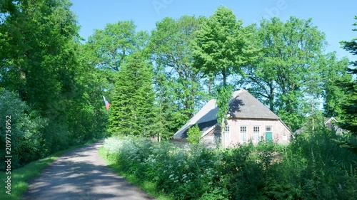 Traditional dutch farmhouse with a thatched roof in a lush forest landscape