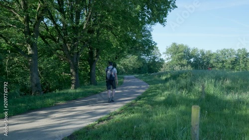 Hiker walking away on a sunny park trail