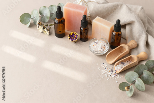 Premium Flat Lay of Natural Herbal Skincare Products with Botanical Soaps, Amber Serum Bottles, Bath Salts, and Fresh Greenery on Soft Pastel Background for Clean Beauty and Wellness Branding